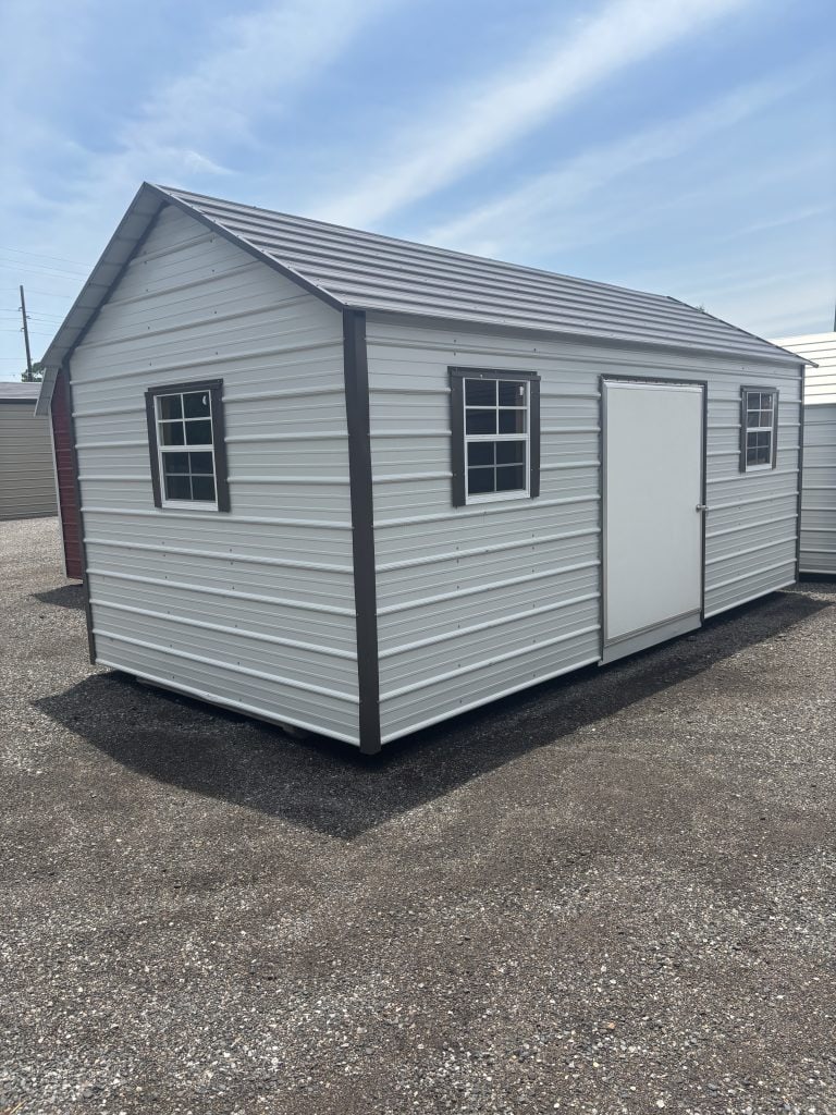 Metal storage shed with windows and a door, perfect for durable outdoor storage solutions.