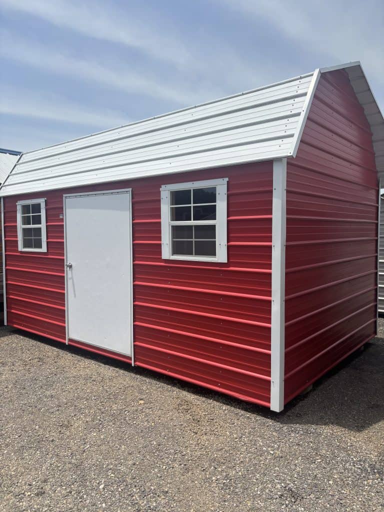 Portable metal storage shed with red exterior and white trim, featuring two windows and a roll-up door, ideal for durable and customizable storage solutions.