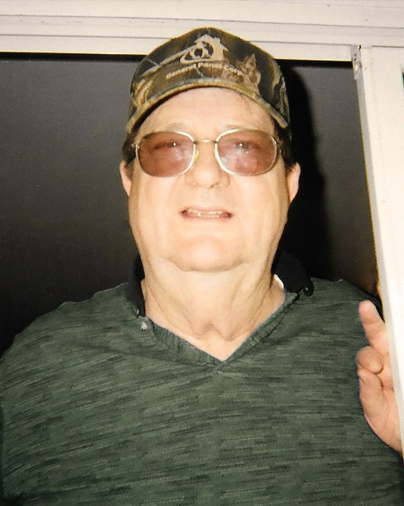 Portrait of a man wearing sunglasses and a camouflage cap, smiling and pointing upward, representing GEMCO Buildings, Inc.