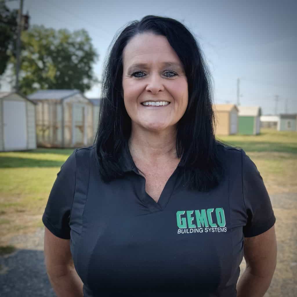 Smiling woman in GEMCO Buildings, Inc. uniform outdoors, representing the company's team and professionalism.